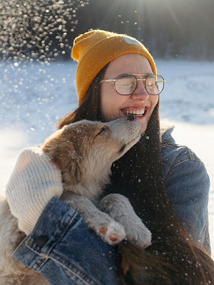 woman holding a dog in the snow