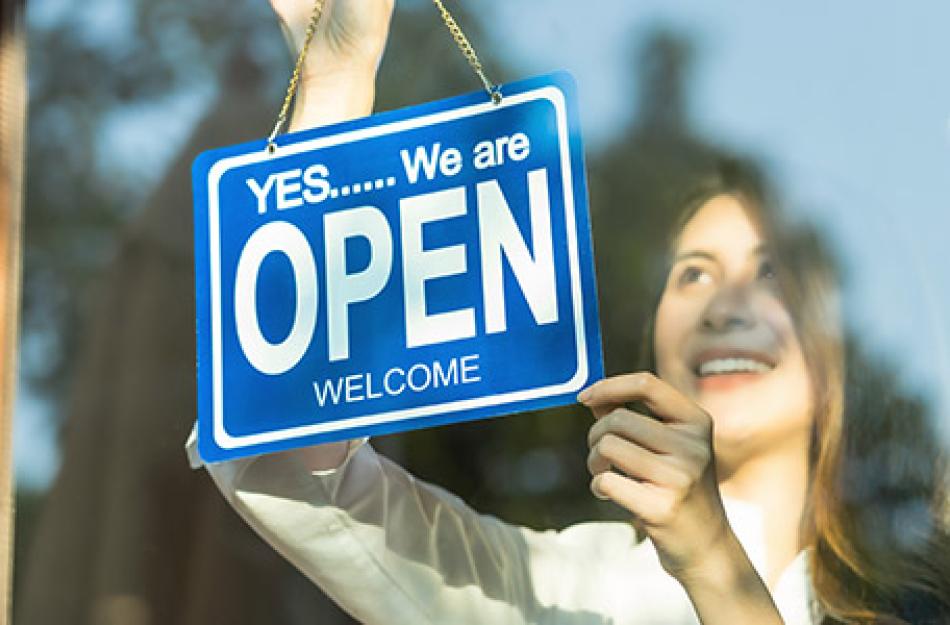 woman changing her business open sign