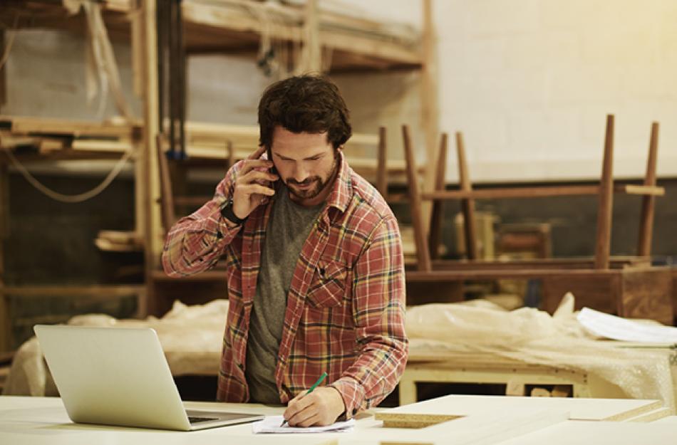 man at a job site looking at a computer