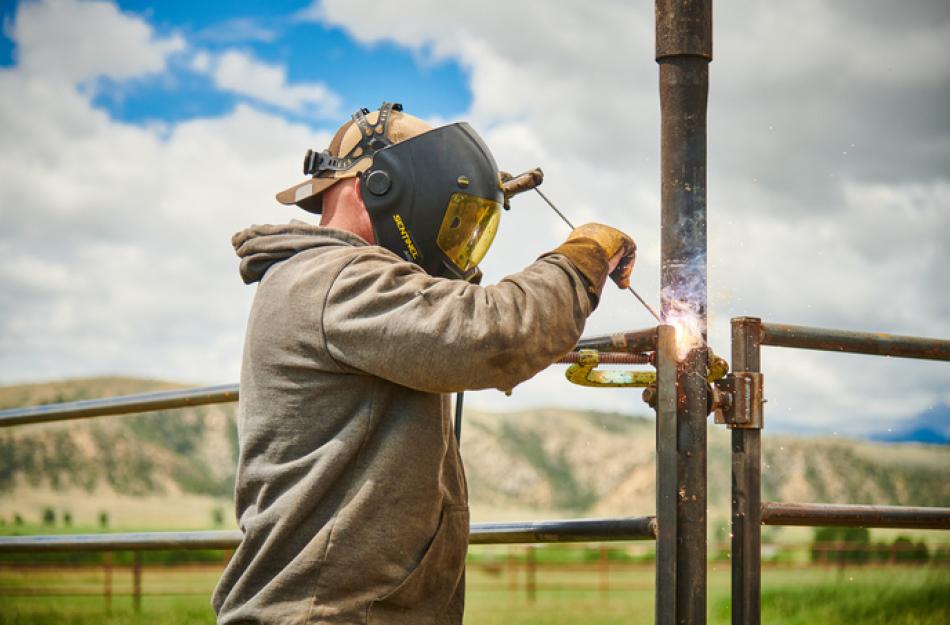 man welding a fence