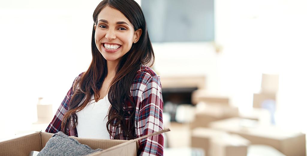 A girl smiling while packing up her house. 