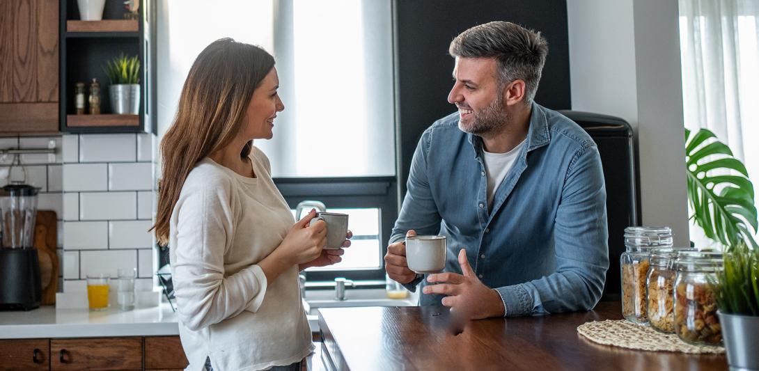 man and woman laughing while having coffee